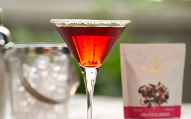 Gros plan de cocktail rouge avec emballage et ingrédients.