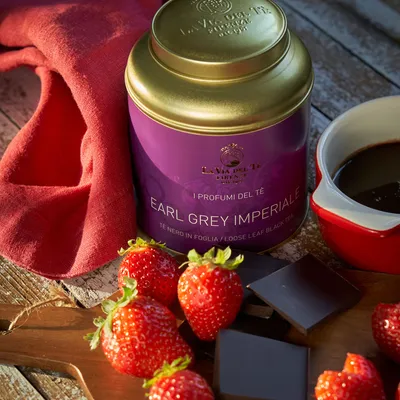 Primo piano di barattolo viola con fragole e dessert cremoso, con confezione ben visibile e ingredienti o accessori disposti intorno alla scena.