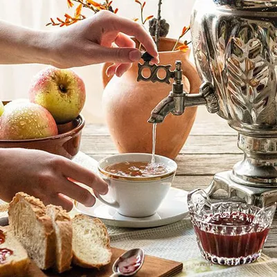Detail of the hands of with person that prepares il tea using with samovar metal.