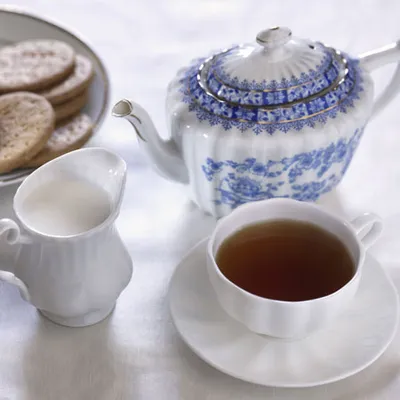 Close-up of cup of tea with teapot blue decorated.