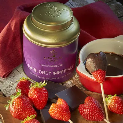 Gros plan de bocal violet avec fraises et dessert crémeux.