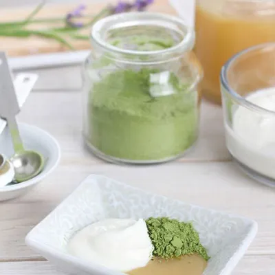 Gros plan de matcha dans polvere sur soucoupe blanc.