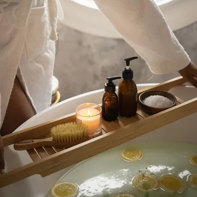 Angolo benessere con lavabo, candele accese, asciugamani e oggetti da cura del corpo, illuminato da luce calda.