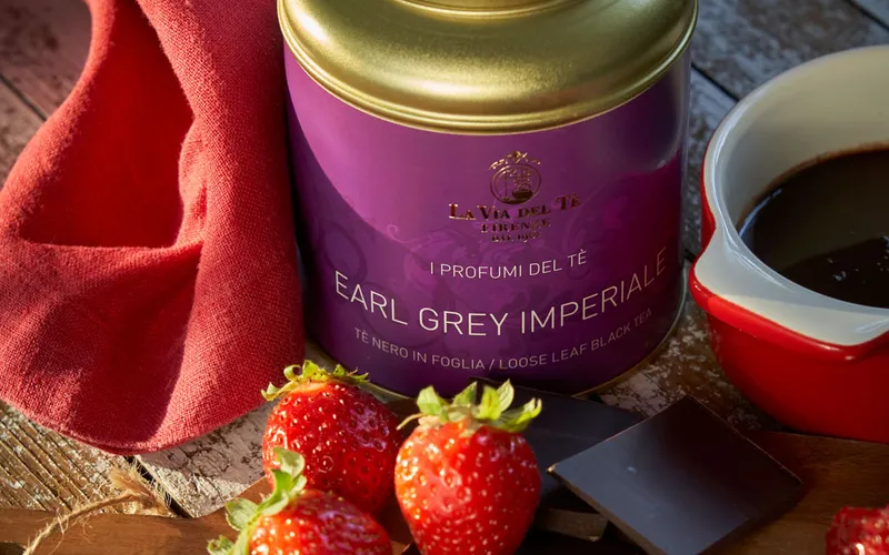 Primo piano di barattolo viola con fragole e dessert cremoso, con confezione ben visibile e ingredienti o accessori disposti intorno alla scena.