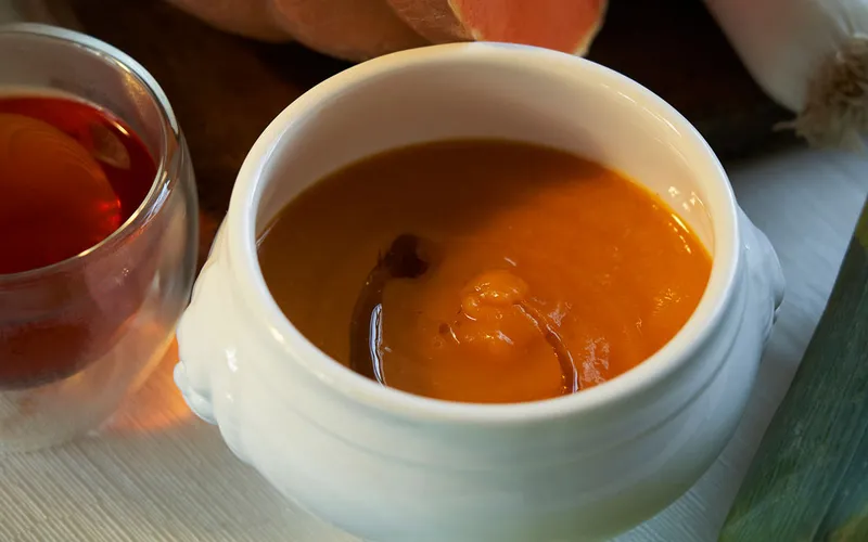 Primo piano di tazza di tè schiumoso in primo piano, ripresa su tavolo o sfondo neutro con attenzione ai dettagli del servizio da tè.