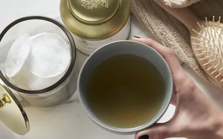 Detail of with hand pours il tea from with contenitore in with cup white.