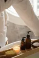 Angolo benessere con lavabo, candele accese, asciugamani e oggetti da cura del corpo, illuminato da luce calda.