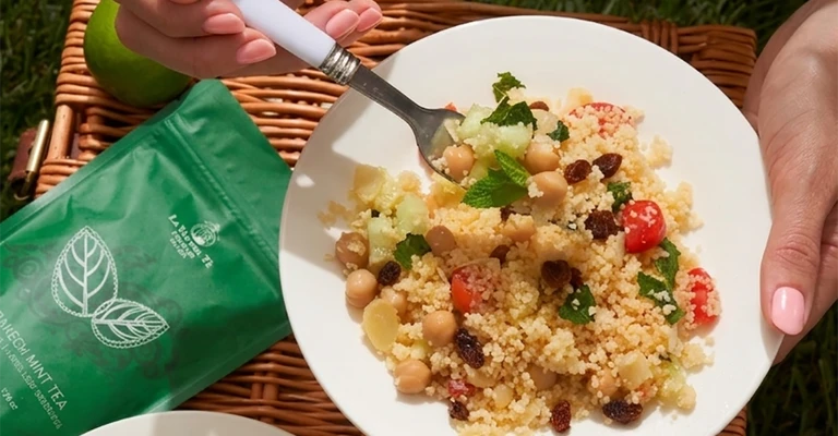 Scena of picnic outdoors with picnic with plate of pasta and bag green.