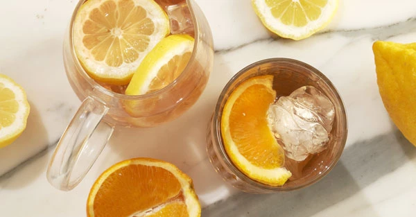 Gros plan de cocktail aux agrumes avec fettine d'orange.
