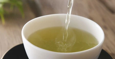 Close-up of tea versato in with cup white.