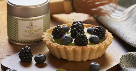 Close-up of berry tart with tea jar.