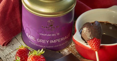 Primo piano di barattolo viola con fragole e dessert cremoso, con confezione ben visibile e ingredienti o accessori disposti intorno alla scena.
