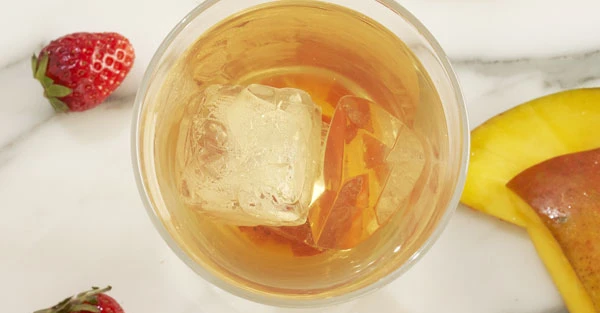 Gros plan d’un verre avec glace et une fetta d'orange appoggiata sur le bordo.