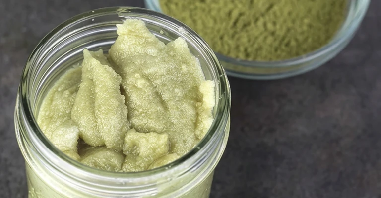 Barattolo de verre rempli avec crème vert au matcha à la texture dense.